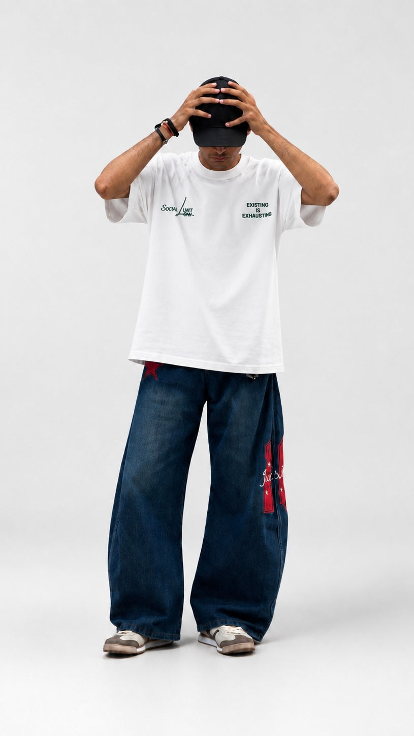 Person wearing a white t-shirt with text on the back, standing against a white background